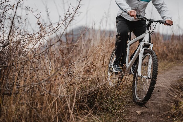 Homem andando de bicicleta de montanha em equipamento especial com espaço de cópia