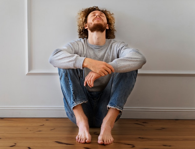 Foto grátis homem ansioso de tiro completo sentado no chão