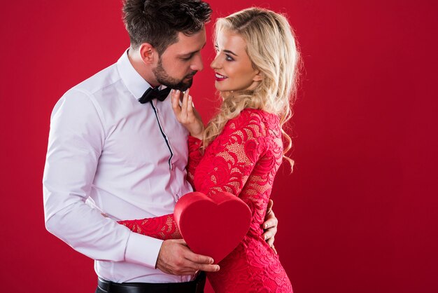Homem ao lado da mulher em fundo vermelho
