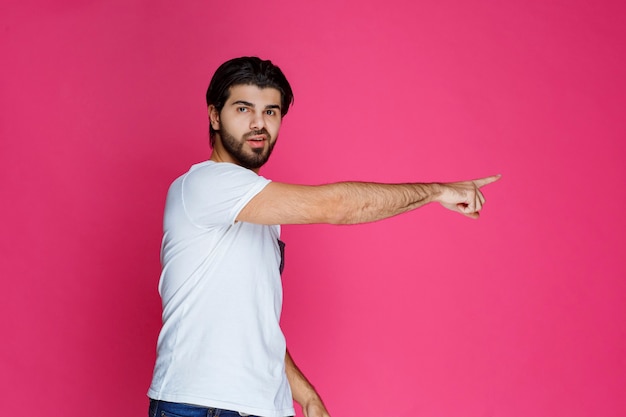 Foto grátis homem apontando para algo ou apresentando alguém.