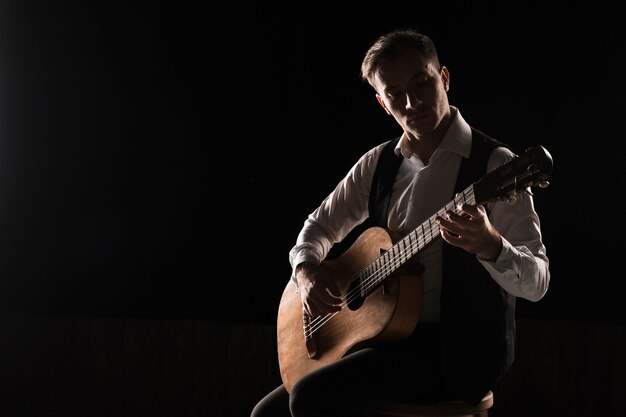 Homem artista no palco tocando o espaço de cópia de guitarra clássica