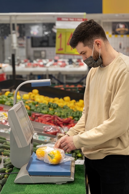 Homem às compras com vista lateral da máscara