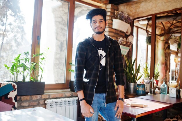 Homem asiático de barba em roupas casuais posando café interior