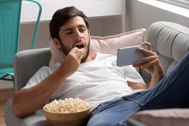 Homem assistindo serviço de streaming em seu telefone