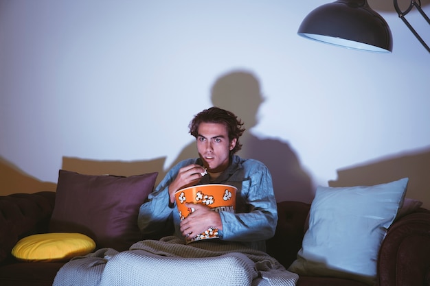 Foto grátis homem assistindo um filme e comendo pipoca