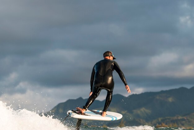 Homem ativo em equipamentos especiais surfando no Havaí