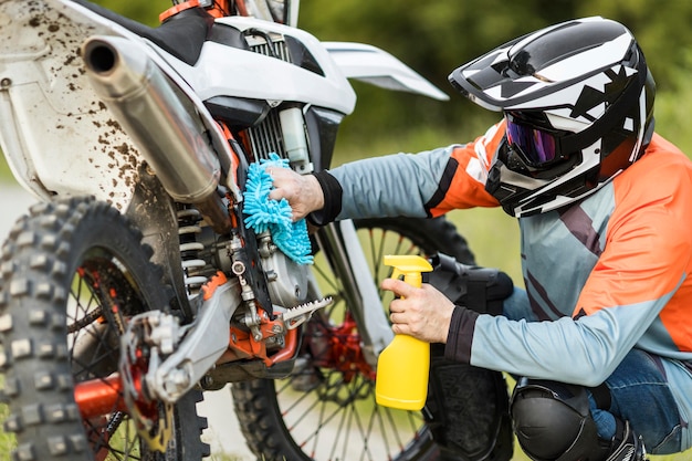 Homem ativo, limpeza de moto ao ar livre