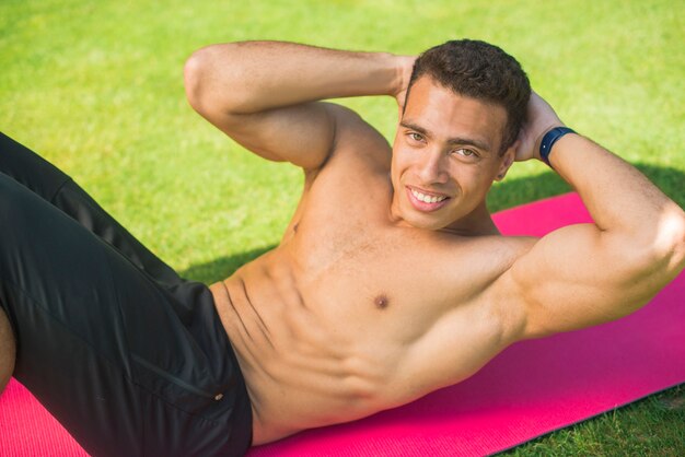 Homem atlético praticando ioga ao ar livre