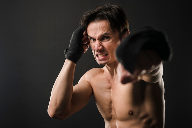 Homem atlético sem camisa em luvas de boxe