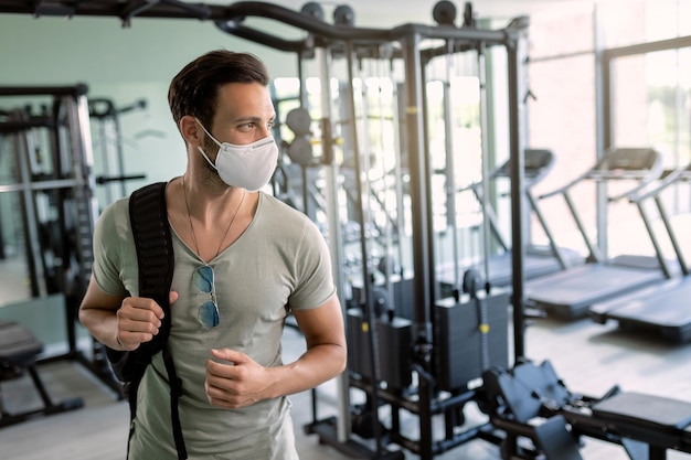 Homem atlético usando máscara facial protetora em uma academia