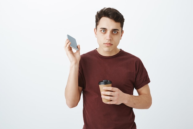 Homem atraente farto de camisa vermelha falando ao telefone