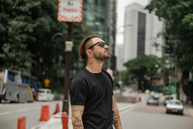 Homem atraente feliz sorrindo na rua em kuala lumpur. homens urbanos, estilo de roupa. bolhas de sabão voam no ar.