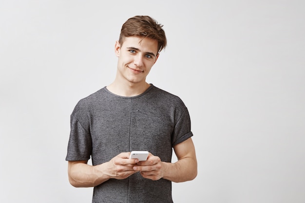 Homem atraente posando com smartphone