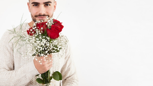 Foto grátis homem atraente segurando cacho de rosas