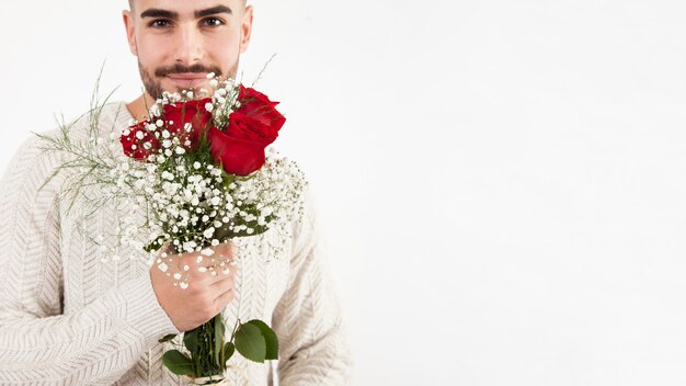 Homem atraente segurando cacho de rosas