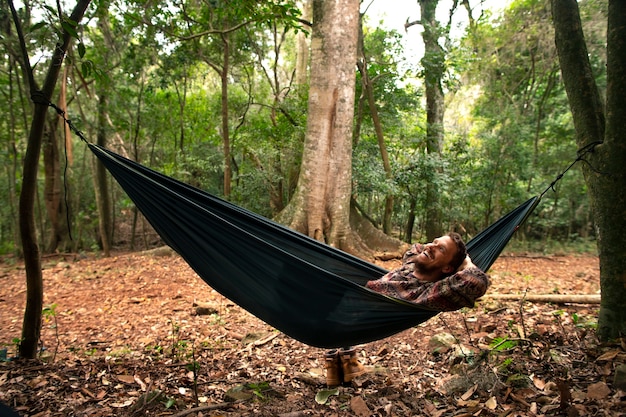 Foto grátis homem aventureiro de tiro completo acampando