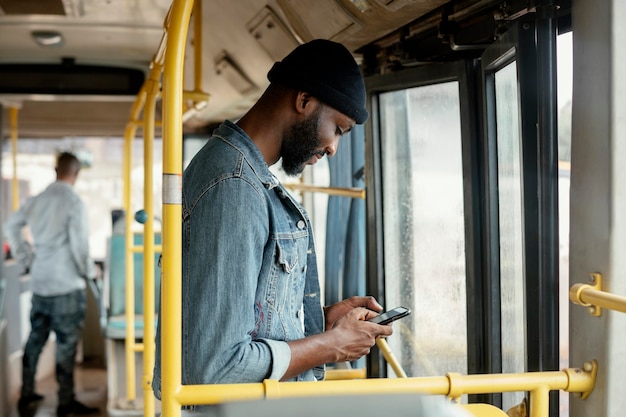 Homem baleado médio com telefone viajando de ônibus