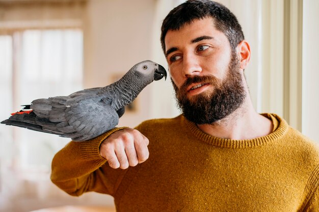 Homem barbudo acariciando um pássaro fofo