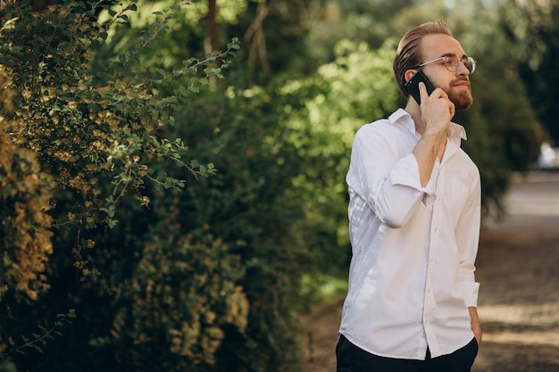 Homem barbudo bonito falando ao telefone