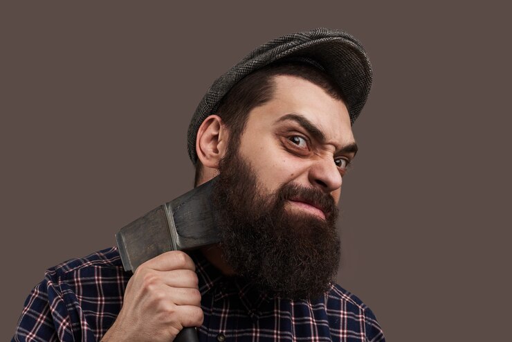 Foto grátis homem barbudo brutal rancoroso barbeado com machado. retrato de hipster com barba. conceito masculino de temperamento explosivo. emoção louca no rosto.