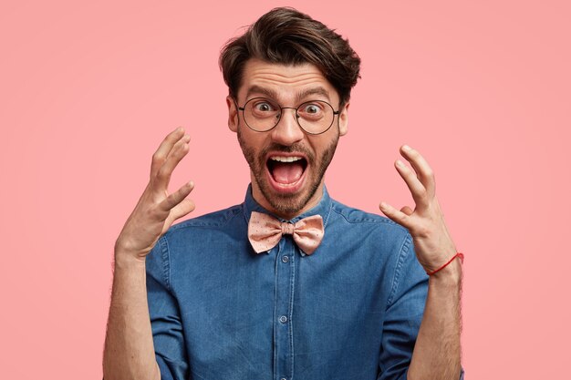 Homem barbudo com camisa jeans e gravata borboleta rosa