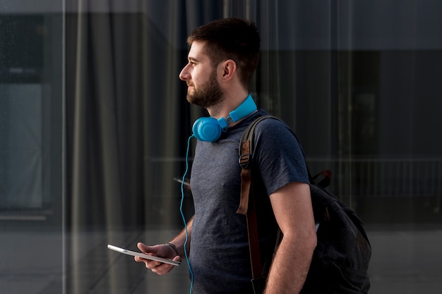 Homem barbudo com fones de ouvido segurando smartphone