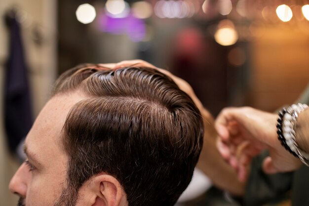 Homem barbudo cortando o cabelo na barbearia