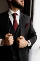 Foto grátis homem barbudo de smoking elegante e gravata vermelha, mãos de homem forte