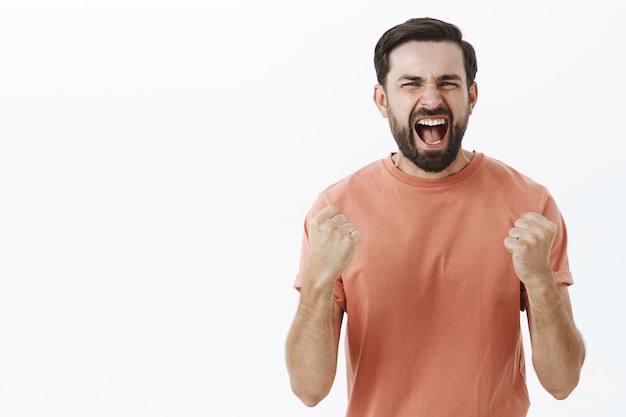 Homem barbudo expressivo em camiseta laranja