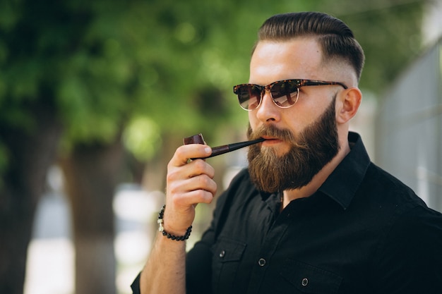 Homem barbudo fumando cachimbo