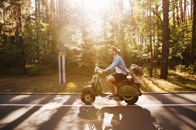 Foto grátis homem barbudo na scooter ao ar livre. olhando de lado.