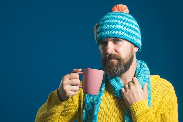 Homem barbudo se aquecendo com chá quente no inverno homem estiloso com barba e bigode bebendo quente