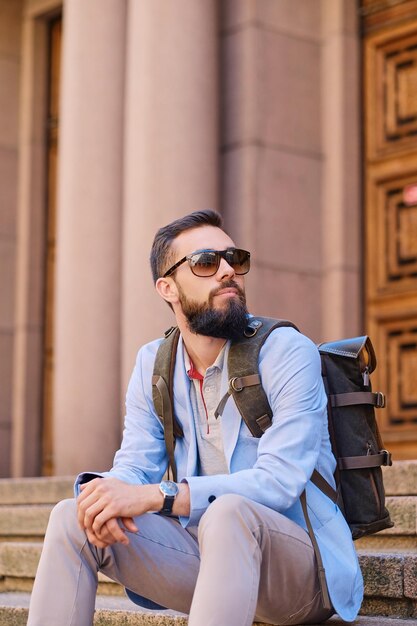 Homem barbudo viajante urbano com uma mochila.