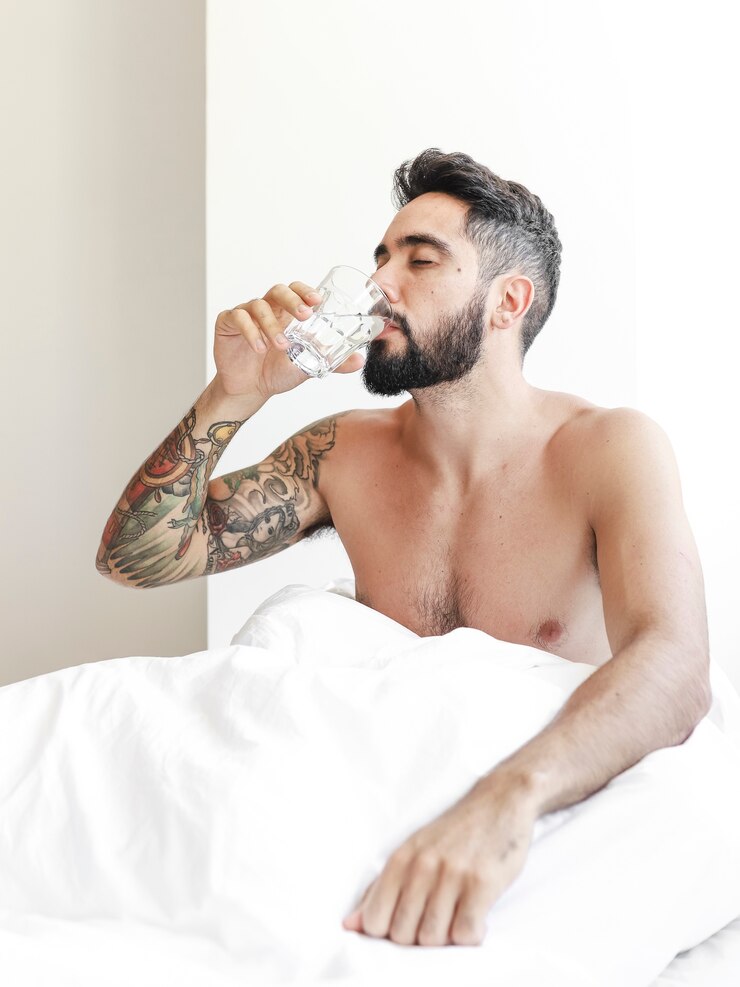 Foto grátis homem bebendo água na cama