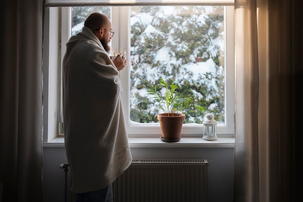 Homem bebendo bebida quente durante crise de energia