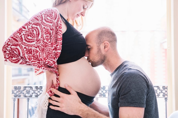 Homem, beijando, mulher grávida