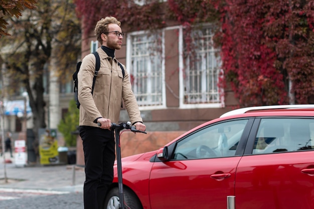 Homem bonito andando de scooter elétrica