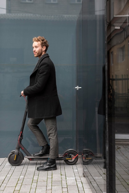 Homem bonito andando de scooter elétrica