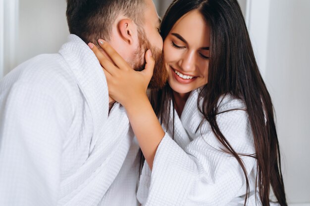 Homem bonito, beijando a mulher bonita na bochecha enquanto