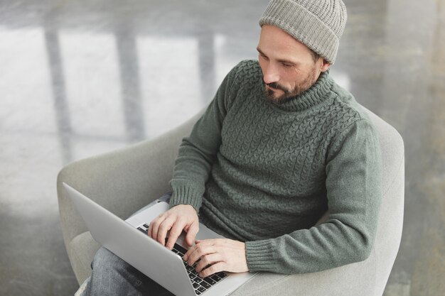 Homem bonito com barba e laptop