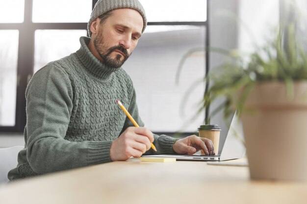 Homem bonito com barba e laptop