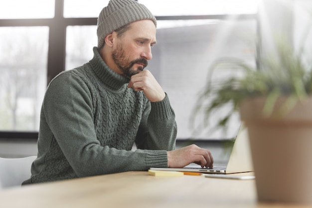 Homem bonito com barba e laptop