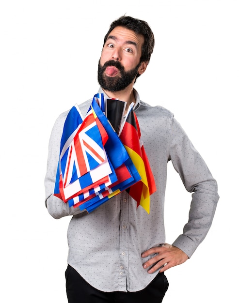 Foto grátis homem bonito com barba segurando muitas bandeiras e fazendo uma piada