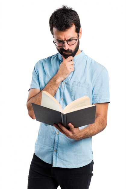 Homem bonito com livro de leitura de óculos azuis