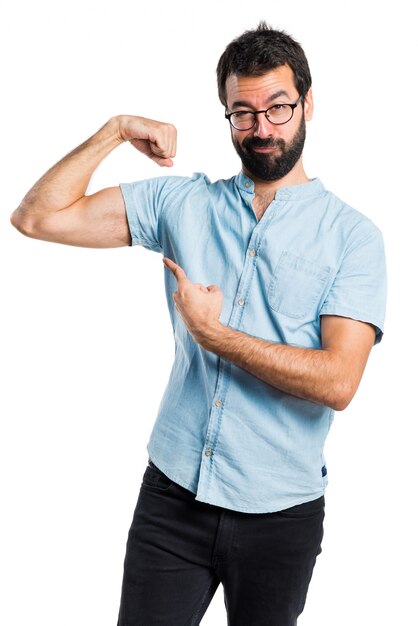 Homem bonito com óculos azuis fazendo um gesto forte