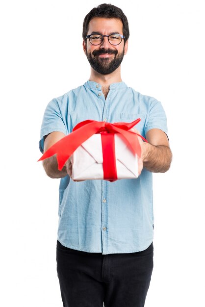 Homem bonito com óculos azuis segurando um presente