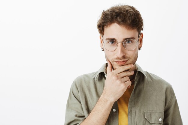 Homem bonito com óculos posando no estúdio