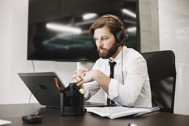 Homem bonito com uma camisa branca. Empresário trabalhando online.