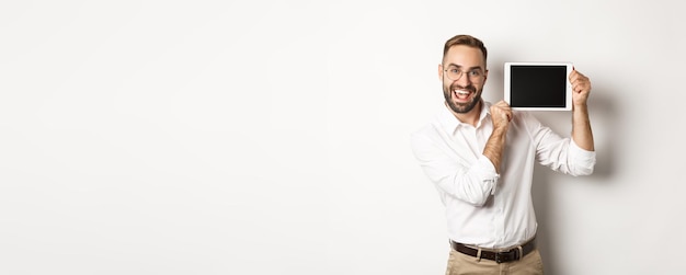 Foto grátis homem bonito de compras e tecnologia mostrando a tela do tablet digital usando óculos com colarinho branco