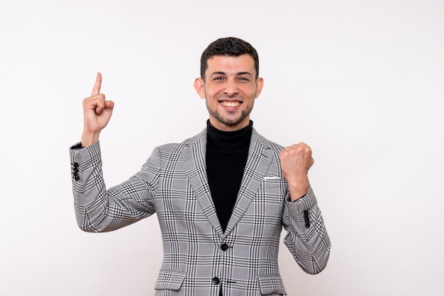 Homem bonito de frente para o terno apontando para o pé-direito no fundo branco